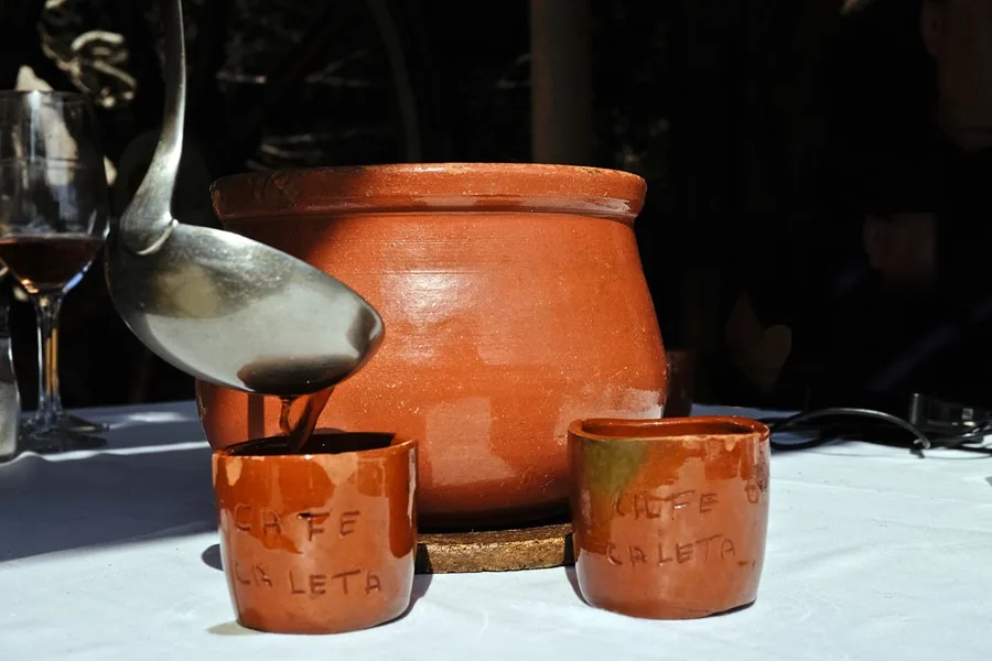 Café Caleta served in clay cups engraved with its name